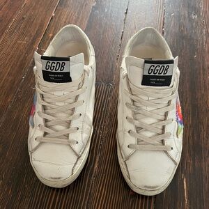 Golden Goose Superstar distressed sneakers with tie dye stars accents.